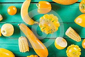 Yellow fruits and vegetables on a turquoise wooden background. Colorful festive still life. Copyspace. Yellow squash, melon, lemon