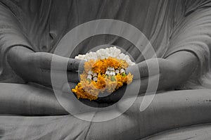 Yellow garland in hands of Buddha statue black and white