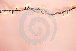 Yellow garland on a pink background. Holiday Christmas concept