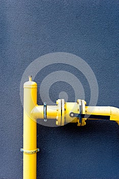 Yellow gas pipe and blue wall