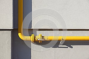 Yellow gas pipe in front of residential building wall