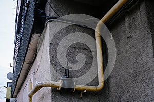 Yellow gas pipe in front of residential building wall, gas pipe in front of residential building wall