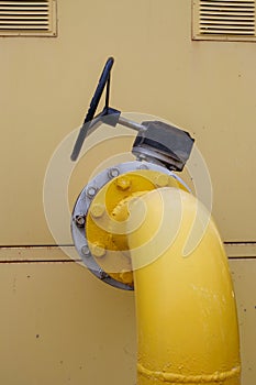 Yellow gas pipe with a tap. Oil pipeline fittings in the oil and gas industry. Oil and gas processing plant with pipeline fittings