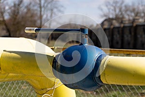 Yellow gas pipe with valve. Transportation, delivery of gas to consumers. Manual shut-off valve service with pipeline gas.