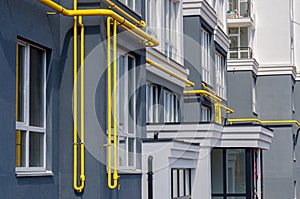 Yellow gas pipe with a vent on the facade of a multi-storey building. Natural gas for domestic household use, gas pipe line