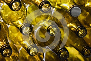 Yellow glass empty beer bottles lie in rows,Glass beer bottles lie in rows, necks on camera, shallow depth of sharp