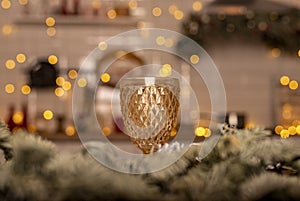 Yellow glass for wine ove blurred background of kitchen decorated for christmas with lights