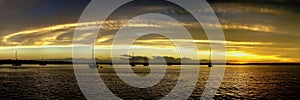 Yellow and gold coloured cirrostratus cloudy coastal nautical Sunset Seascape panorama. Tin Can Bay, Queensland, Australia