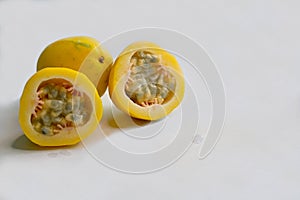 Yellow or golden passion fruit, whole and cut, on white background