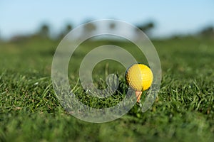 Yellow golf ball on the ground at the driving range