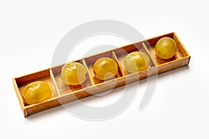 Yellow grapes lie in wooden cells a box an isolated item on a white background