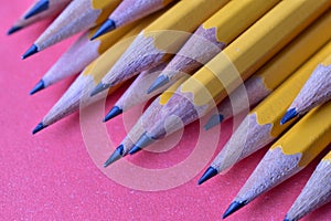 Yellow graphite pencils on a pink background