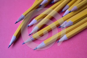 Yellow graphite pencils on a pink background