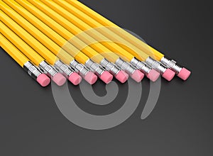 Yellow graphite pencils in a row on a dark background