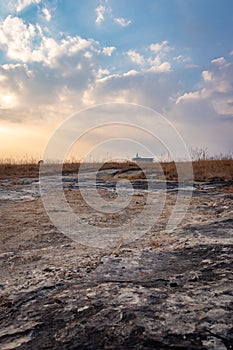 Yellow grass field with isolated church and dramatic sky at morning from different angle