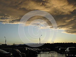 Yellow gray storm clouds. Cumulonimbus dramatic sky wave formation over the city. Weather after the thunderstorm, light