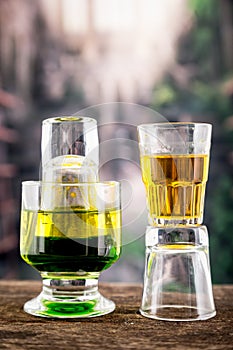 Yellow green cocktail inside a glass and shot