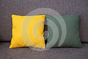 Yellow and green cushions decorating a gray sofa