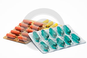 Yellow green and orange gelatin capsules pills in blister pack