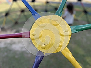 Yellow green and red monkey bars Toddler playing at the park