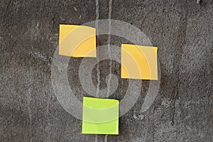 Yellow and green sticky notes papers handing on the gray wall