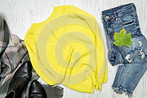 Yellow-green sweater, scarf and jeans. Fashionable concept