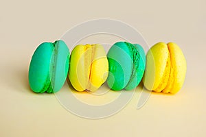 Yellow and green sweet tasty macaroons on yellow background.