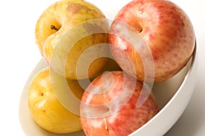 Yellow green sweetie and red pluot fruits