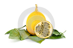 yellow Grenadilla oval fruit on a green leaf substrate, an exotic fruit with a fragrant filling