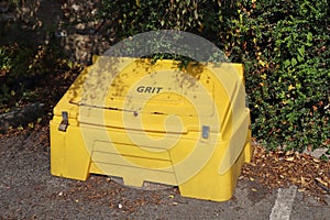 A yellow grit bin in a public car park in readiness for winter driving conditions