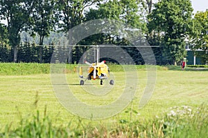 Yellow gyrocopter standing on a meadow photo
