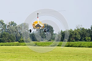 Yellow gyroplane departing from the airport photo