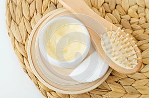 Yellow hair mask (banana face cream, shea butter mask, mango body butter) in a small white container and hairbrush.