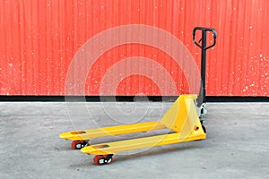 Yellow hand pallet truck in the warehouse front