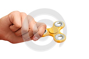 Yellow hand spinner. Boy playing a popular toy fidget spinner in his hand. Stress relief. Anti stress and relaxation