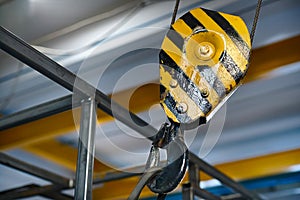 Yellow hanging crane in the workshop close-up