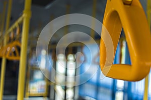 Yellow  hanging handhold for standing passengers in a modern bus. Suburban and urban transport