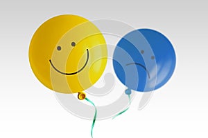 Yellow happy balloon and blue sad balloon flying away on white background - Prevalence of positive over negative mood conept photo