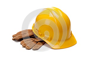 A yellow hard hat and leather work gloves on white