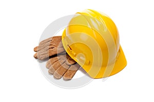 A yellow hard hat and leather work gloves on white