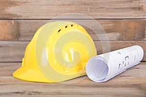 Yellow hard hat and rolled drawings for construction