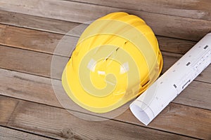 Yellow hard hat and rolled drawings for construction