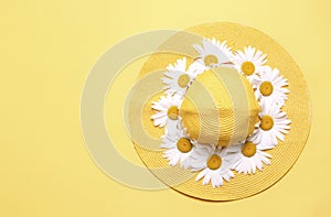 Yellow hat decorated with flowers top view empty space background,summer vocation backdrop