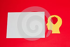 yellow head with strawberry in it looking at white copy paper, red background, creative art design