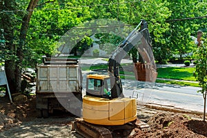 Yellow heavy duty digger working in excavation pit photo