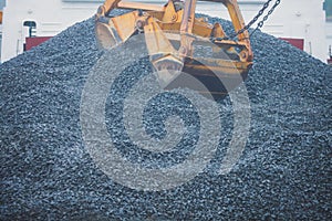 Yellow heavy excavator and bulldozer excavating sand and working during road works, unloading sand and road metal during construct