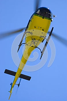 Yellow helicopter in blue sky