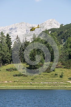 Yellow helicopter landing in the mountains