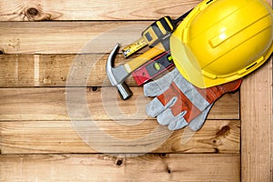 Yellow helmet for construction work and tools on the plank