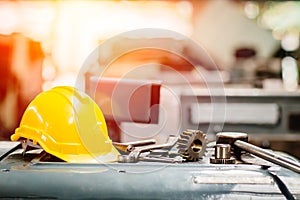 Yellow helmet hardhat with instruments gear tools in factory for background